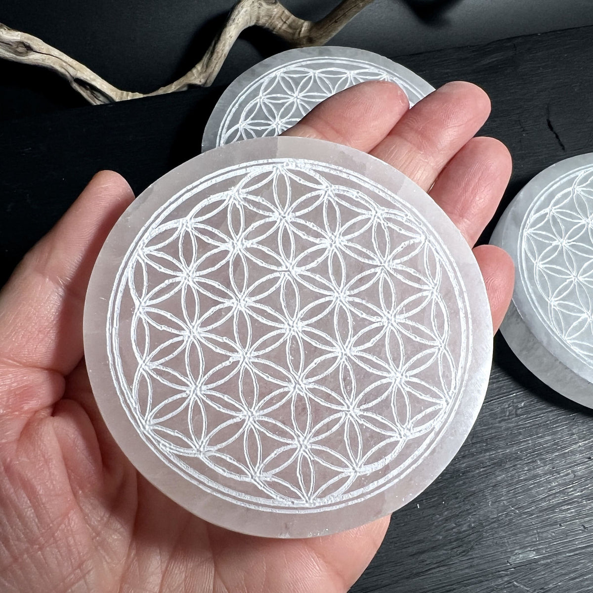 Selenitplatte 8cm in der Hand gehalten zeigt perfekte Größe als Schmuck Ladeplatte