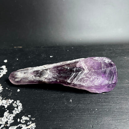Amethyst Massagegriffel liegend | Chevron-Muster sichtbar | violett-weiße Bänderung | Happy Minerals