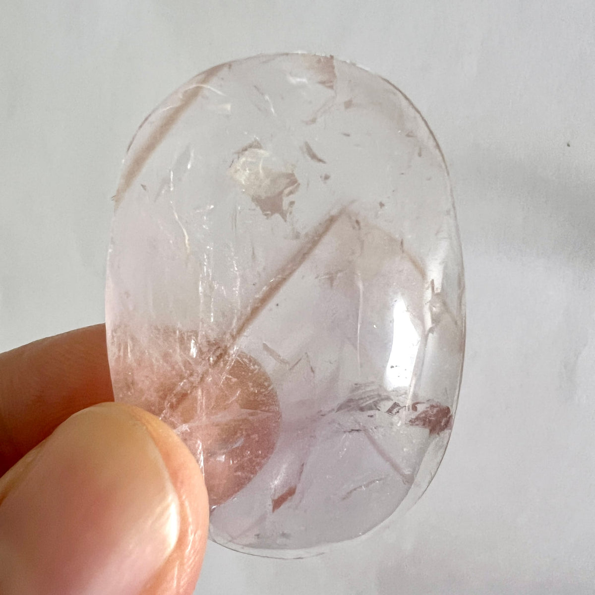 Bergkristall Handschmeichler, oval-poliert, glasklar mit diagonalen Rissen, braunen Schlieren und Fluorit-Einschlüssen | Happy Minerals
