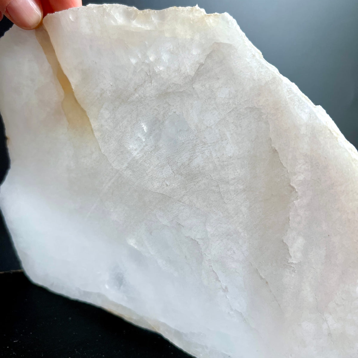 Bergkristall Platte milchig-weiss mit grauen Wolken, rohe gezackte Kante, in Hand gehalten | Happy Minerals