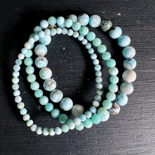 Larimar Armbaender aus runden Perlen in meerblau-tuerkis mit weissen und braunen Marmorierungen, hochglaenzend poliert | Happy Minerals