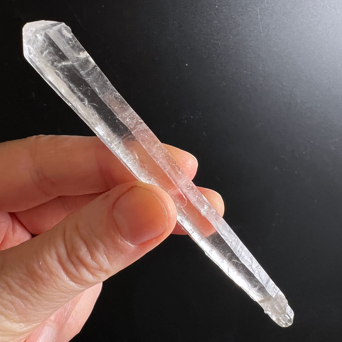 Lemurian Quarz Doppelender, klar mit feinen Streifen und einem Regenbogeneinschluss, in Hand gehalten | Happy Minerals
