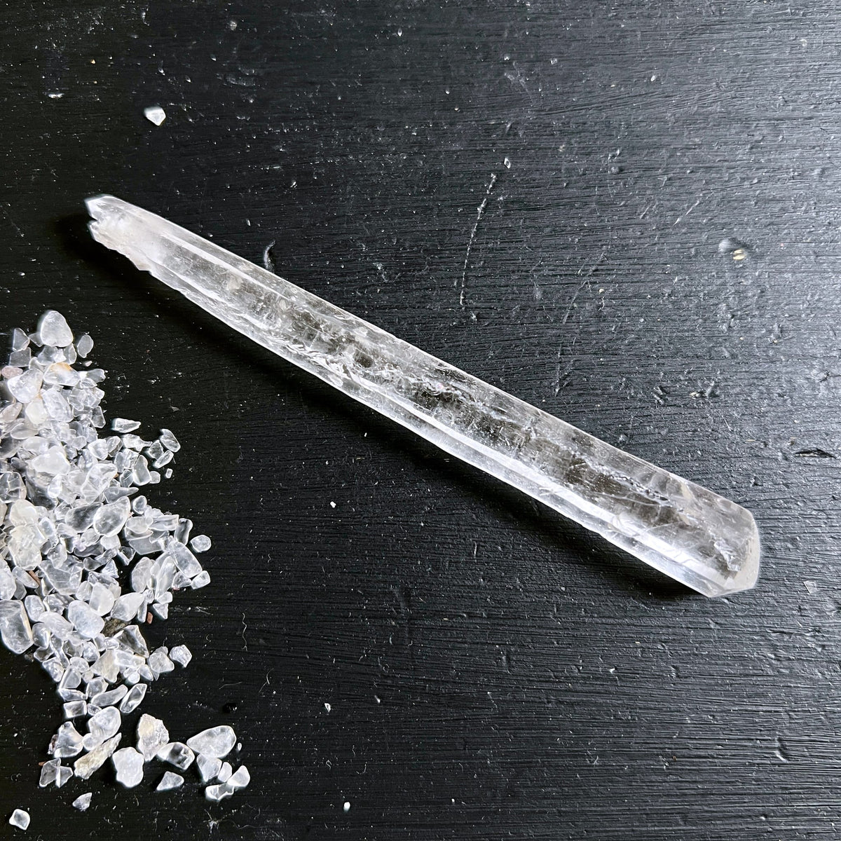 Lemurian Quarz Doppelender, klar-transparenter Stab mit feinen Riefen und Leitern, auf schwarzem Holz | Happy Minerals