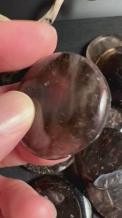 Mehrere Rauchquarz Taschensteine in Hand zeigen Farbvariationen