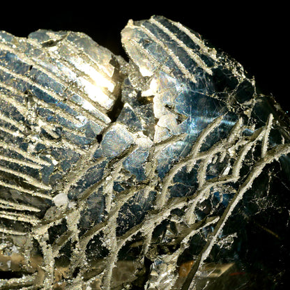 Pyrit Nahaufnahme mit metallisch-goldenem Glanz, gravierten Linienmustern und blaustichigen Facetten | Happy Minerals
