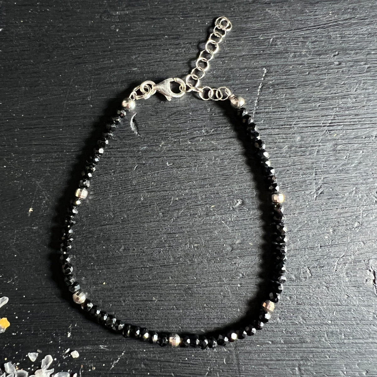 Komplettes Spinell Armband flach liegend auf dunklem Holz | silberne Akzentperlen | Happy Minerals Unikat