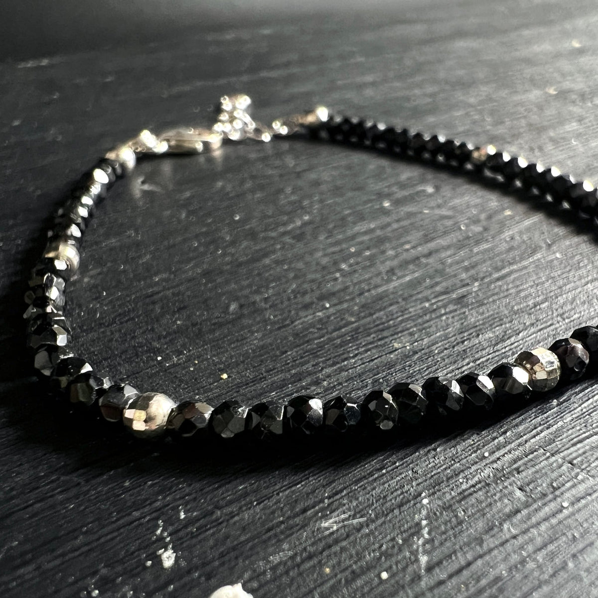 Nahaufnahme geschwungenes Spinell Armband auf Schieferuntergrund | funkelnde Facetten | Happy Minerals