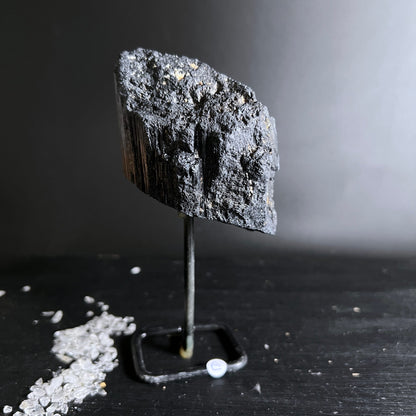 Schwarzer Turmalin Rohstein mit faserig-glänzender Bruchkante auf Metallständer | Happy Minerals