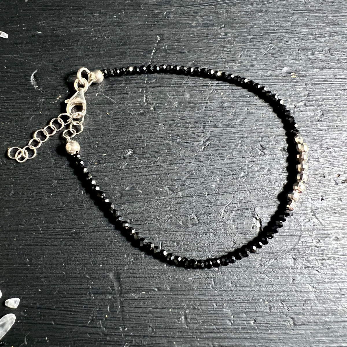 Kreisförmig | drapiertes | Spinell-Armband | mit silbernem | Karabinerverschluss | auf dunklem Holz | Happy Minerals