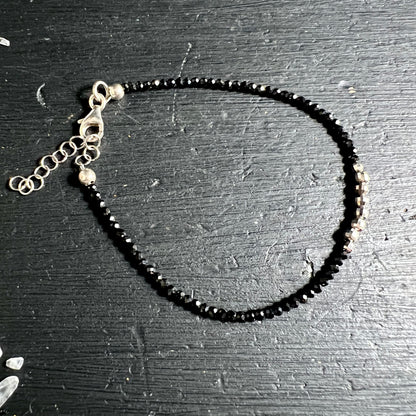 Kreisförmig | drapiertes | Spinell-Armband | mit silbernem | Karabinerverschluss | auf dunklem Holz | Happy Minerals
