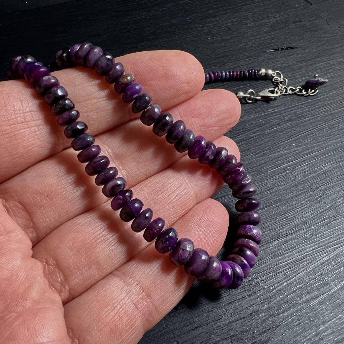 Elegante violette Sugilith Edelsteinkette auf schwarzem Holz Hintergrund | Happy Minerals