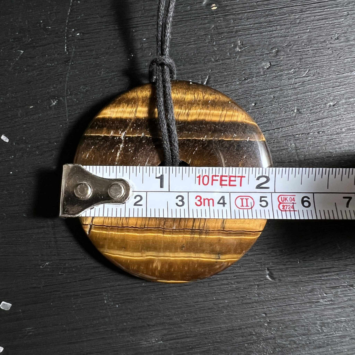 Tigerauge Donut Anhänger mit Massband zeigt 50mm Durchmesser