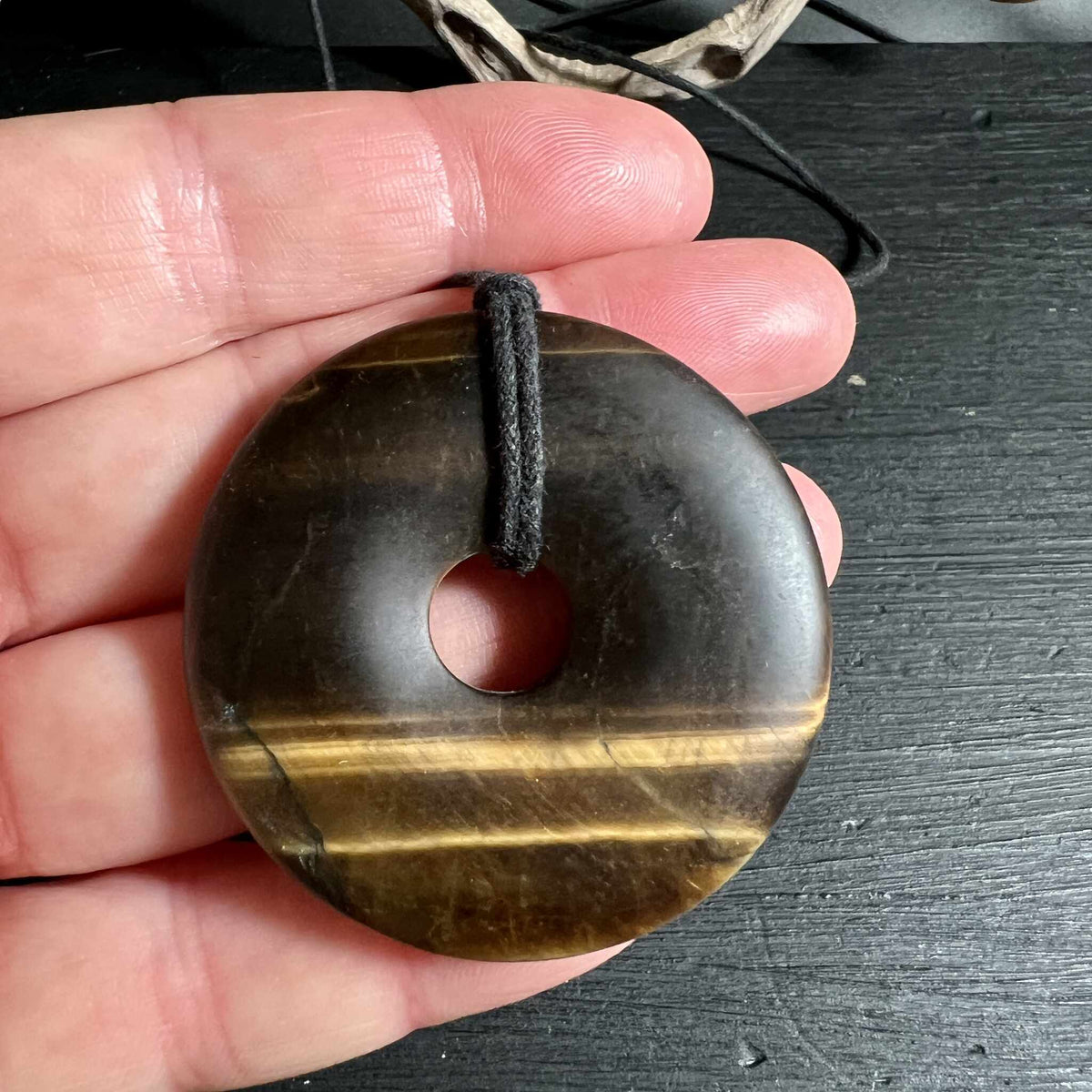 Matter Tigerauge Donut in der Hand zeigt 50mm Groesse